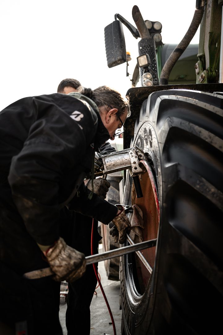 Due tecnici Ermes Gomme al lavoro su pneumatico trattore Fendt officina Poirino